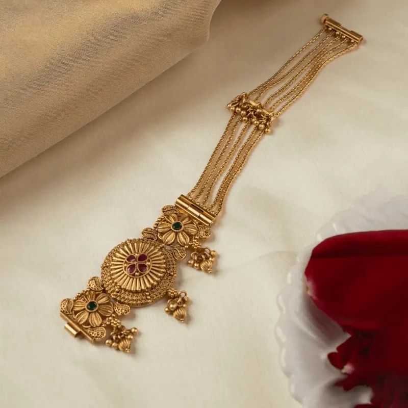 Padmavalli statement bracelet with ruby pink and emerald accents in antique gold-tone finish by Ruhratna
